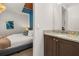 Bathroom featuring a granite-topped vanity adjacent to a bedroom with a stylish accent wall at 420 Burma St, Kissimmee, FL 34747