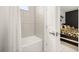 Bright bathroom featuring a soaking tub with tile surround and a glimpse into an adjacent bedroom at 420 Burma St, Kissimmee, FL 34747