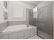 Bright bathroom featuring a soaking tub, a glass shower, and tile throughout at 420 Burma St, Kissimmee, FL 34747