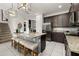 Spacious kitchen featuring granite countertops, stainless steel appliances, a kitchen island with barstool seating, and stylish lighting at 420 Burma St, Kissimmee, FL 34747
