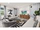 Open-concept living room with stylish decor, featuring modern furnishings, contemporary lighting, and a media center with a large TV at 420 Burma St, Kissimmee, FL 34747