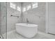 Elegant bathroom features a sleek soaking tub set against a stunning marble tile backdrop and bright natural light at 423 Arbor Cir, Celebration, FL 34747
