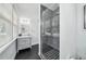 Modern bathroom with black herringbone tile, a glass-enclosed shower, and natural light at 423 Arbor Cir, Celebration, FL 34747