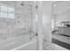 Well-lit bathroom featuring a shower-tub combination, glass door, marble tiling and an adjacent bedroom in view at 423 Arbor Cir, Celebration, FL 34747