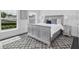 Cozy bedroom features a neutral color palette with a gray bed frame and plush rug, illuminated by natural light at 423 Arbor Cir, Celebration, FL 34747