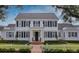 Classic white home with symmetrical design, black shutters, and neat landscaping for enhanced curb appeal at 423 Arbor Cir, Celebration, FL 34747