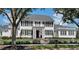 Charming two-story home features a white picket fence, black shutters, and a well-manicured lawn at 423 Arbor Cir, Celebration, FL 34747