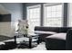 Cozy living room with large windows, a dark couch, and decoratively stacked vintage suitcases at 423 Arbor Cir, Celebration, FL 34747