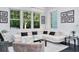 A brightly lit living room shows the leather couch, large windows, and light coming in from outside at 423 Arbor Cir, Celebration, FL 34747