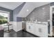 Stylish wet bar featuring white cabinets, gray backsplash, and stainless steel mini-fridge at 423 Arbor Cir, Celebration, FL 34747
