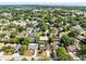 Expansive aerial view of a residential neighborhood featuring lush green landscaping, mature trees, and several homes with private pools at 4412 Mesa Verde Dr, St Cloud, FL 34769