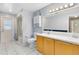 Bright bathroom featuring double sinks, a tub with shower, and white tile flooring at 4412 Mesa Verde Dr, St Cloud, FL 34769