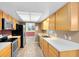 Well-lit kitchen with wood cabinets, stainless steel appliances, and a view of the dining area at 4412 Mesa Verde Dr, St Cloud, FL 34769