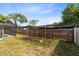 Backyard garden area with a wooden fence, covered in a black net structure at 4412 Mesa Verde Dr, St Cloud, FL 34769