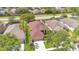 Aerial view of a house with a brown roof and solar panels in a neighborhood with trees at 5114 Olde Kerry Dr, Orlando, FL 32837