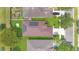 Aerial view of home showcasing solar panels on roof and well-manicured yard at 5114 Olde Kerry Dr, Orlando, FL 32837