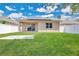 Lush backyard featuring a well-maintained lawn and solar panels on the roof of the home at 5114 Olde Kerry Dr, Orlando, FL 32837
