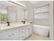Elegant bathroom featuring a dual-sink vanity, soaking tub, and modern fixtures at 5114 Olde Kerry Dr, Orlando, FL 32837