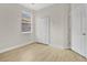 Bright bedroom with wood-look flooring, a window with blinds, and a closet with bifold doors at 5114 Olde Kerry Dr, Orlando, FL 32837