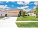 Well-maintained single-Gathering home with a two-car garage, lush lawn, and mature trees at 5114 Olde Kerry Dr, Orlando, FL 32837