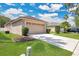 Spacious two-car garage with long driveway and well-kept lawn and minimal landscaping at 5114 Olde Kerry Dr, Orlando, FL 32837