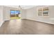 Bright, airy living room featuring wood-look floors, large windows, and sliding glass doors at 5114 Olde Kerry Dr, Orlando, FL 32837