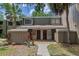 Inviting townhome exterior with a well-maintained lawn, mature trees, and a welcoming entryway at 5234 Eaglesmere Dr # D04, Orlando, FL 32819