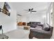 Open-concept living room featuring tile floors, modern ceiling fan, and a comfortable leather sofa at 5234 Ohio St, Winter Park, FL 32792