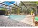 Pool area with brick patio, tropical landscaping, and screened enclosure at 5234 Ohio St, Winter Park, FL 32792