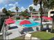 Community pool surrounded by lounge chairs and red umbrellas for shade at 5245 W Irlo Bronson Memorial Hwy # 148, Kissimmee, FL 34746