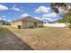 Large backyard featuring lawn, fence, and rear exterior of the house, perfect for outdoor activities at 561 Lake Cummings Way, Lake Alfred, FL 33850