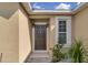 Welcoming front door with decorative sidelights and lush landscaping at 561 Lake Cummings Way, Lake Alfred, FL 33850