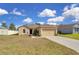 Single-story home with a two-car garage and well-kept lawn, perfect for families at 561 Lake Cummings Way, Lake Alfred, FL 33850