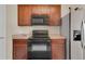Charming kitchen features wooden cabinetry, black appliances, and a functional layout at 561 Lake Cummings Way, Lake Alfred, FL 33850