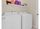 Bright laundry room features new white washer and dryer with shelf space for organization at 561 Lake Cummings Way, Lake Alfred, FL 33850