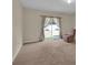 Bright living room with plush carpeting, sliding glass doors to backyard, and neutral color scheme at 561 Lake Cummings Way, Lake Alfred, FL 33850