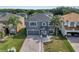 This is an aerial shot of a two-story home with a brick driveway, lush landscaping, and a gray color scheme at 5768 Los Palma Vista Dr, Orlando, FL 32837