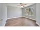 Bright bedroom with wood-look flooring, ceiling fan, and a large window providing plenty of natural light at 5768 Los Palma Vista Dr, Orlando, FL 32837