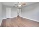 Comfortable bedroom with wood-look flooring, ceiling fan, closet and an open door that leads to another room at 5768 Los Palma Vista Dr, Orlando, FL 32837