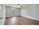 Cozy bedroom with wood-look flooring, ceiling fan, and window that allows natural light at 5768 Los Palma Vista Dr, Orlando, FL 32837