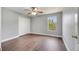 Inviting bedroom with a ceiling fan, wood-look flooring, and a window offering a serene outdoor view at 5768 Los Palma Vista Dr, Orlando, FL 32837