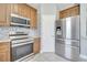 Modern kitchen featuring stainless steel appliances, stylish backsplash, and warm wood cabinetry at 5768 Los Palma Vista Dr, Orlando, FL 32837