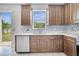 Bright kitchen featuring wood cabinets, quartz countertops, tile backsplash, and modern appliances at 5768 Los Palma Vista Dr, Orlando, FL 32837