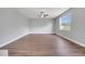 Spacious living room features wood floors, a ceiling fan, and natural light from the large picture window at 5768 Los Palma Vista Dr, Orlando, FL 32837