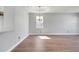 Expansive living room with wood flooring, a modern light fixture, and natural light from a single window at 5768 Los Palma Vista Dr, Orlando, FL 32837