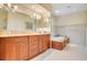Bathroom showcases a built-in soaking tub, double vanity with granite countertops, and tile flooring at 606 N Mcdonald St, Mount Dora, FL 32757