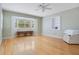 Spacious bedroom featuring hardwood floors, a large window, and built-in shelving at 606 N Mcdonald St, Mount Dora, FL 32757
