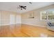 Spacious bedroom features hardwood floors, a ceiling fan, and a sunlit window with shutters at 606 N Mcdonald St, Mount Dora, FL 32757