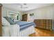 Bedroom view featuring wood flooring, dresser, bed with blue comforter, and natural lighting at 606 N Mcdonald St, Mount Dora, FL 32757