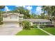 Charming exterior elevation of the home with a well-manicured lawn, lush landscaping, and inviting curb appeal at 606 N Mcdonald St, Mount Dora, FL 32757